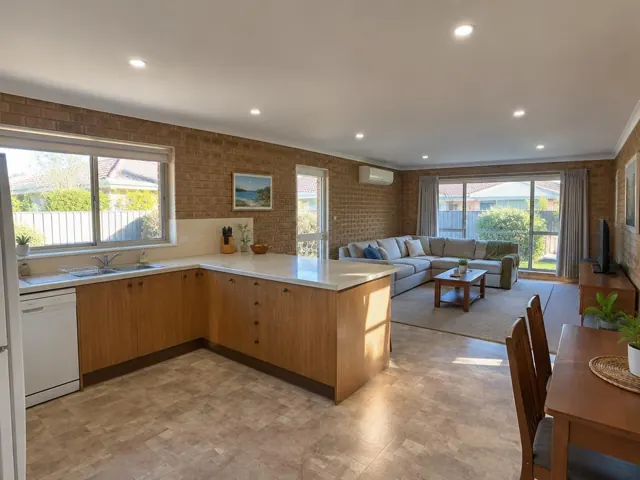 Living room and kitchen with recessed ceiling downlights in a brick-walled home in Cardiff