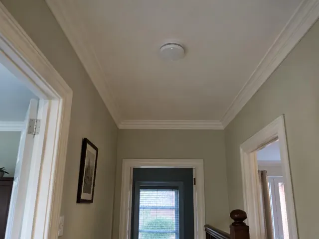 Hallway ceiling smoke alarm above painted walls and door trims in New Lambton